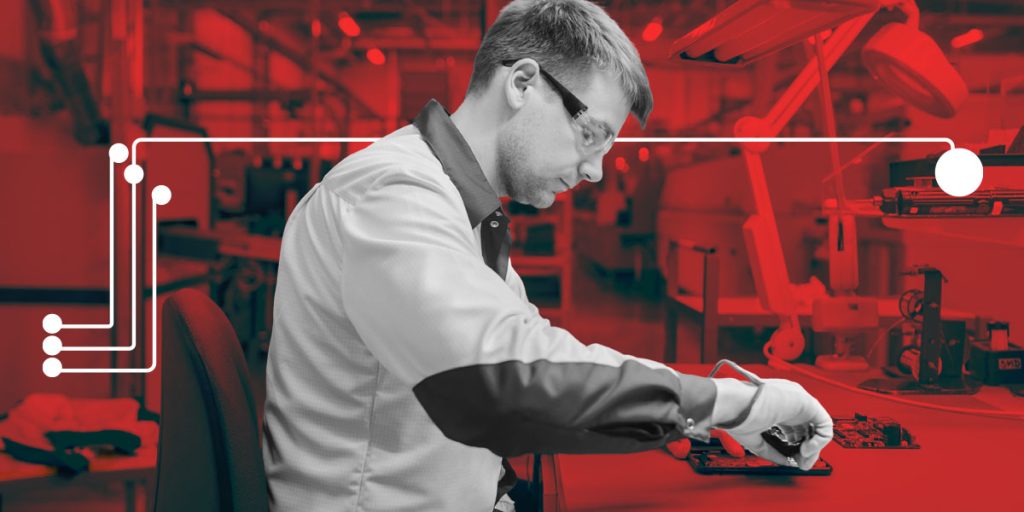 Man working on electrical manufacturing with safety gloves and goggles. 